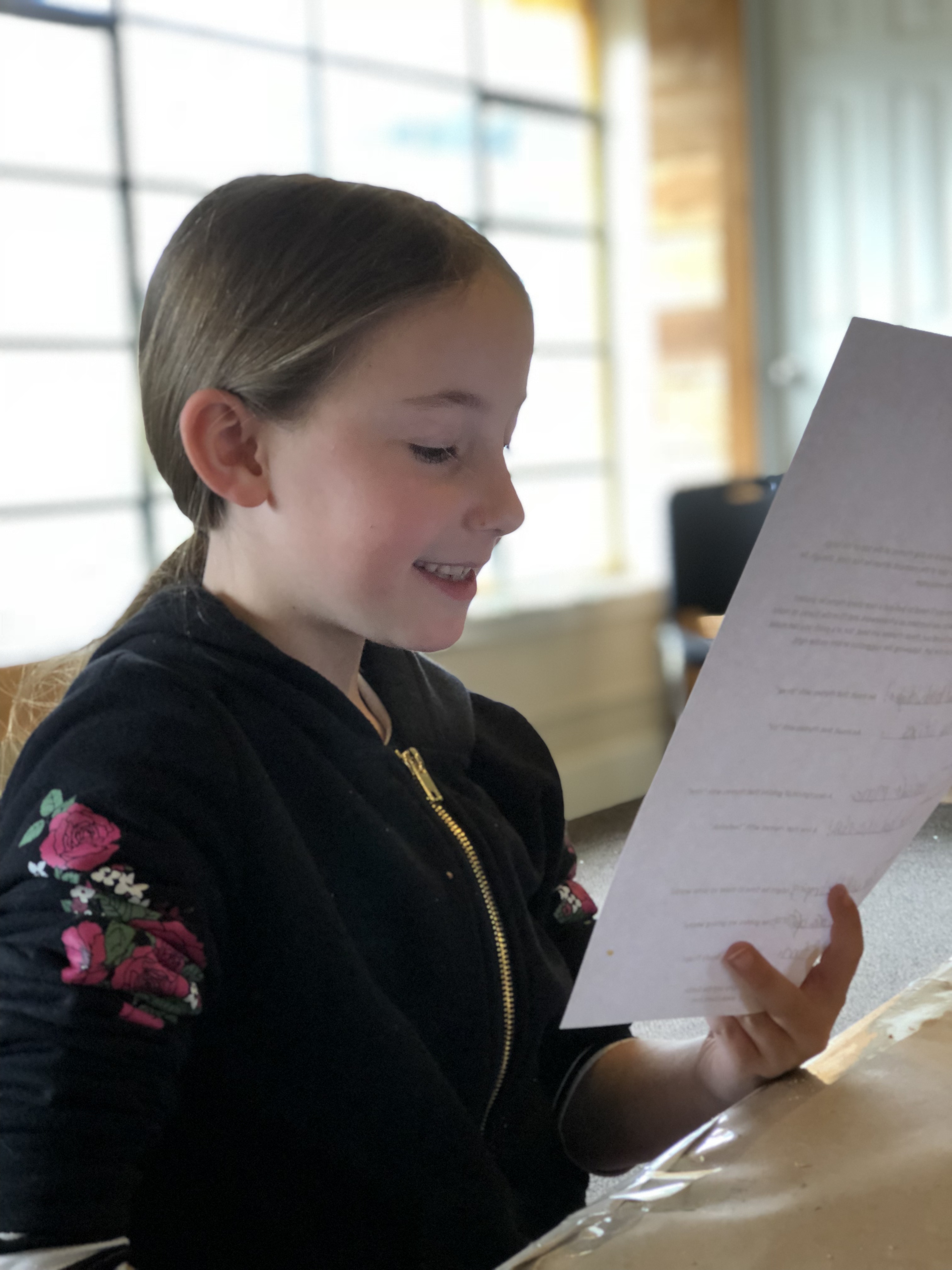 A child reading her writing aloud to practice  "write what you know," a creative writing activity for teaching THE BIRCHBARK HOUSE by Louise Erdrich - LitWits Workshops
